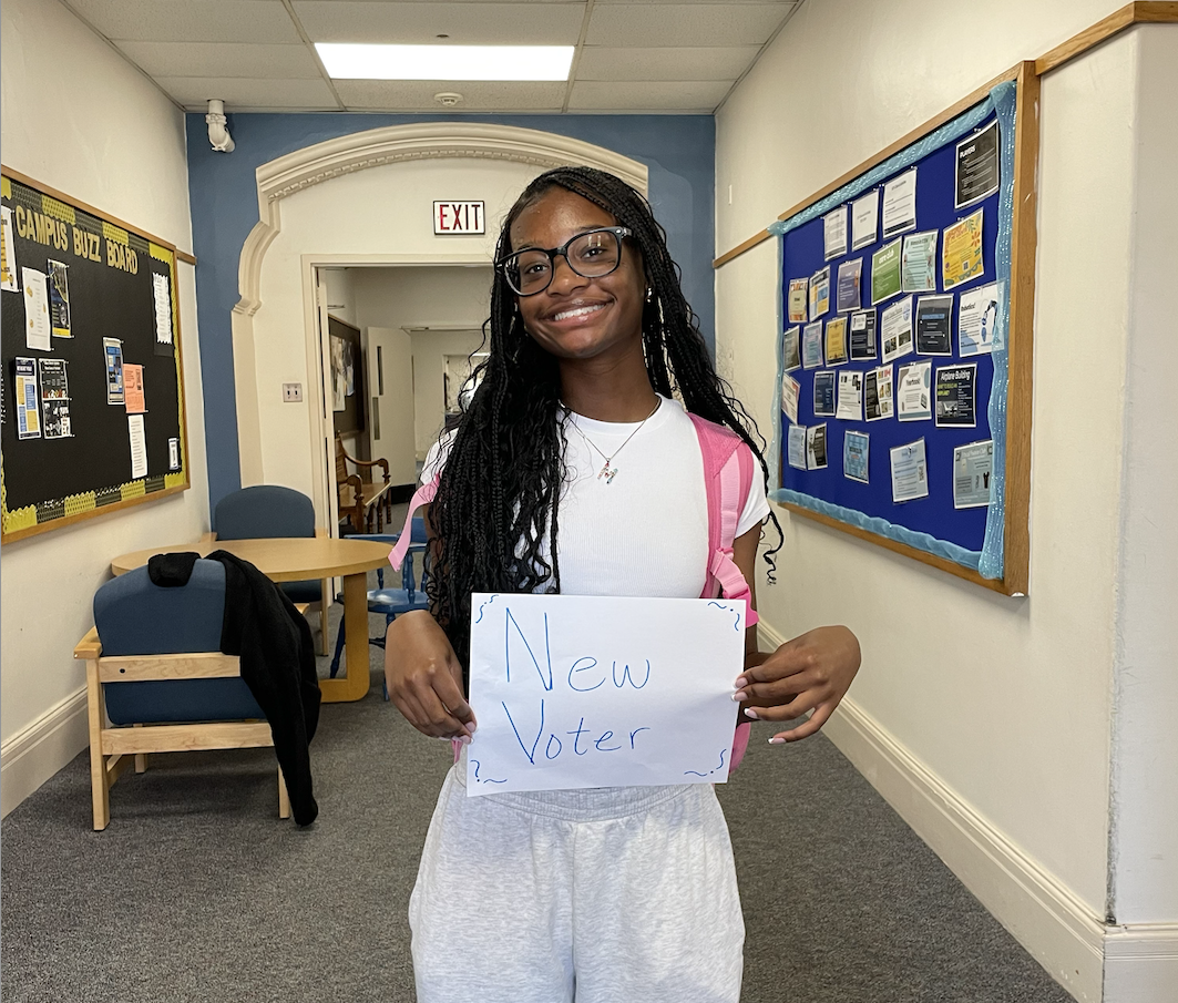 Morgan Hines '25 holding new voter sign